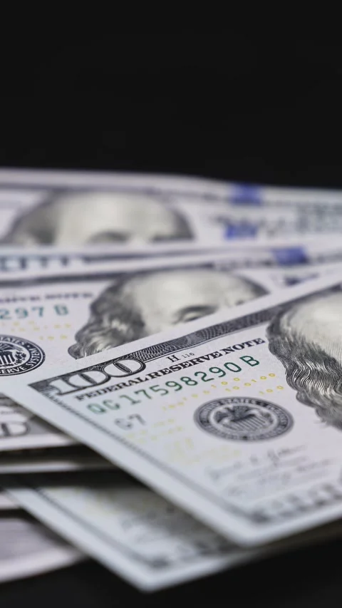 Close-up sequence of U.S. hundred-dollar bills being stacked and fanned out on a Stock Footage 328124774