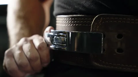 Close-up sequence of a weightlifter fastening a heavy leather powerlifting belt 库存影片 329819901