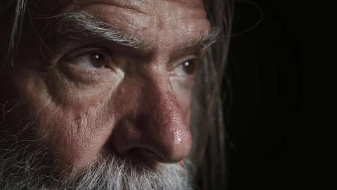 Close up on serious and pensive old man in the dark Stock Footage 74994347