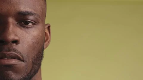 Close-up of a serious black man looking sadly into the camera and smiling Stock Footage 233612569