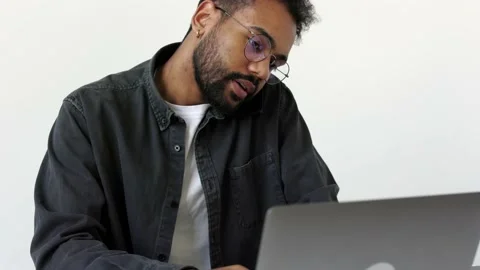 Close up serious black skinned man in grey shirt talking on cell phone holding Stock Footage 196127194