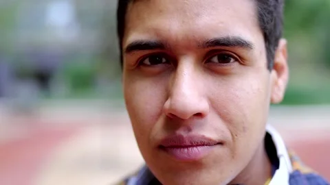 Close-up of a serious hispanic student looking at camera outdoors Stock Footage 258326192