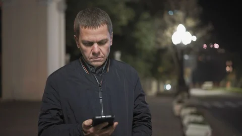 Close-up Of A Serious Man Calling From A Smartphone Standing In The Middle Of Stock Footage 97664617