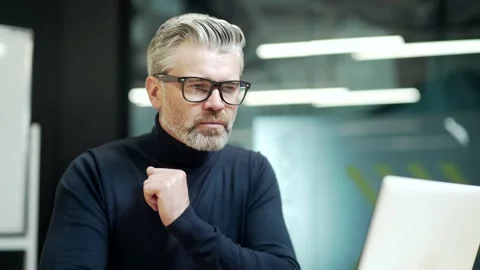 Close up of serious mature gray haired bearded businessman in glasses looking in Stock Footage 232580270