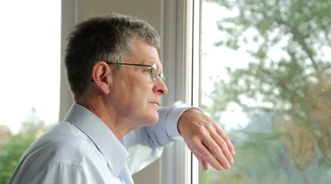 Close up, serious, sad middle aged man looks out of the window Stock Footage 33605916