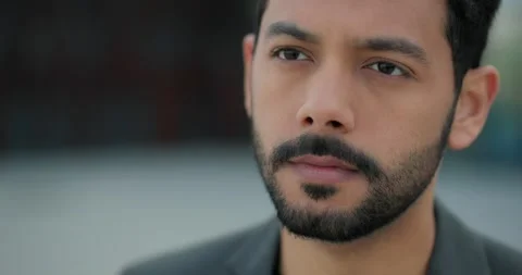 Close up of a serious young man raises his eyes and looks forward. Stock Footage 244512438