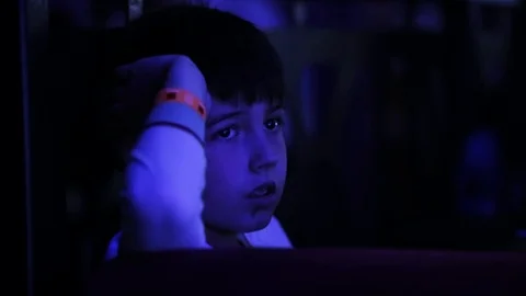 Close up seriously young pretty boy sitting looking blue light childhood candy Stock Footage 98215738