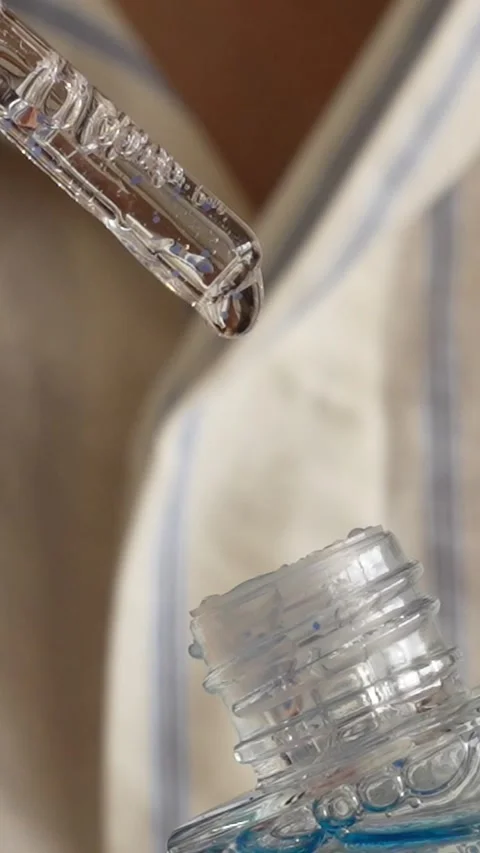 Close-Up of Serum Dropper Dripping Onto Bottle Stock Footage 287788715