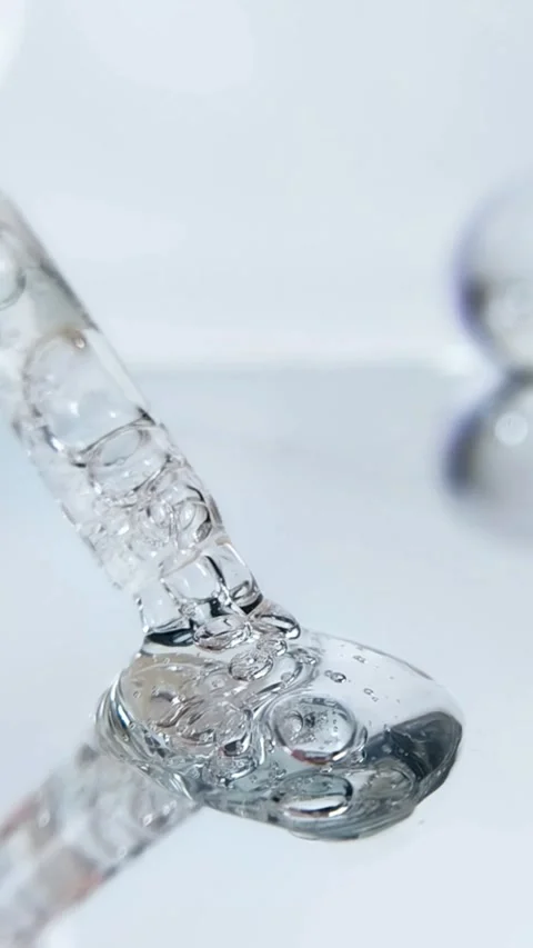 Close up serum pipette with bubbly liquid. Beauty liquid on glass reflection Stock Footage 335296875