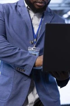 Close up of server farm worker troubleshooting errors on laptop Foto stock