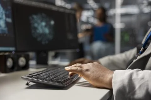 Close up of server hub engineer typing on PC keyboard, looking at data Stock Photos