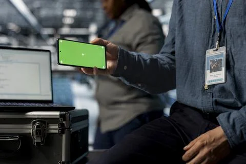 Close up of server room admin using chroma key phone, watching videos Foto stock