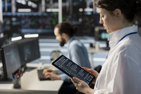 Close up of server room programmer using tablet to pinpoint performance issues Stock Photos