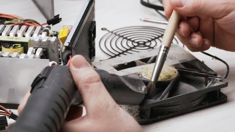 Close-up service worker cleans the PC power supply unit from dust and dirt with Stock Footage 105591195