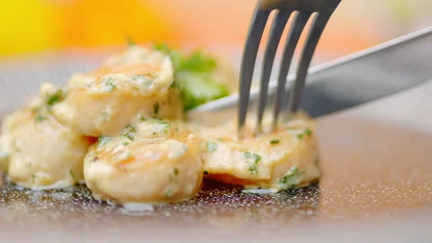 Close-up serving with a fork and knife freshly made creamy scallops in 4K. Stock Footage 138068335