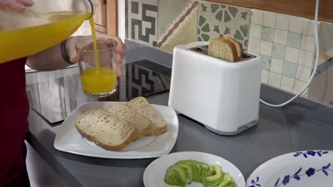 Close-up serving orange juice for breakfast, with avocado and toast Stock Footage 218477163