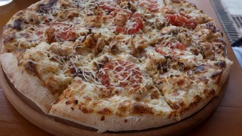 Close up serving pizza on the table. A close up view of pizza with the crispy cr Stock Footage 286794746