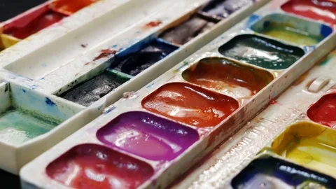 Close up set of colorful watercolors. Sets of watercolor paints on the black  Stock Footage 106565880