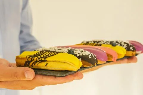 Close-up of set of delicious eclairs with glaze, colorful desserton a tray in Stock Photos