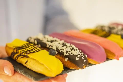 Close-up of set of delicious eclairs with glaze, colorful desserton a tray in Stock Photos