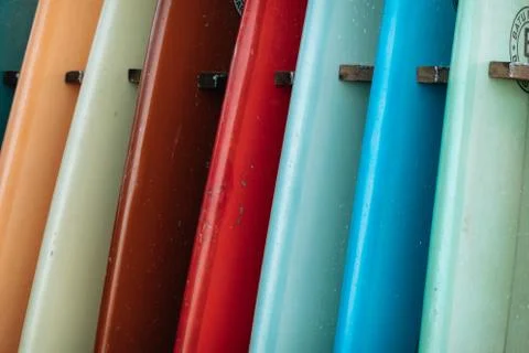 Close up Set of different color surf boards in a stack by ocean. Stock-Fotos