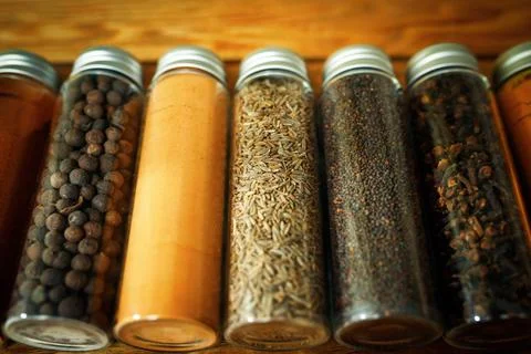 Close-up on a set of different spices in transparent jars - pepper, paprika Stock Photos