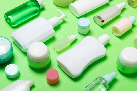 Close-up set of diffrent sized bottles and jars for cosmetic products on gr.. Stock Photos