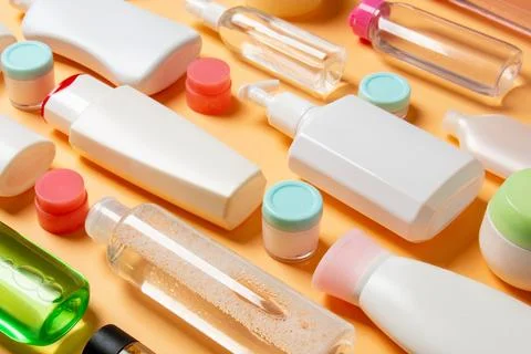 Close-up set of diffrent sized bottles and jars for cosmetic products on co.. Stock Photos