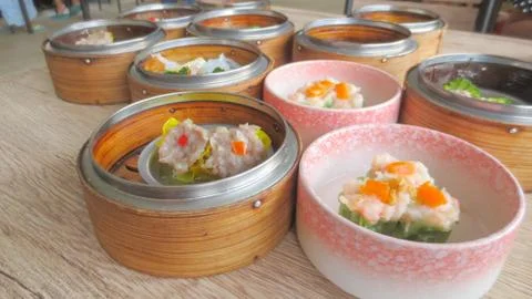Close up of set steamed dim sum dumplings in basket, chinese traditional food Foto stock