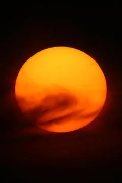 Close-up of the setting sun through the light clouds. 스톡 사진