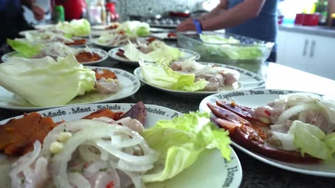Close-up of several ceviche dishes served in the kitchen and several people Stock Footage 178459818