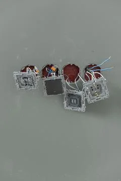 A close-up of several electrical switch boxes with exposed wiring, showcasing Stock Photos