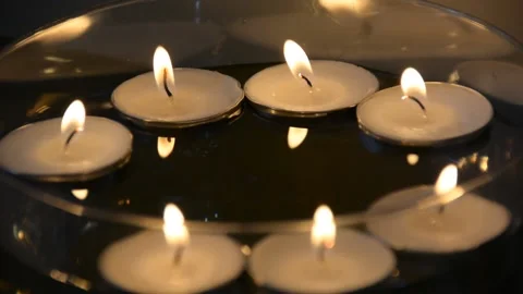 Close up of several floating candles in a glass of water. Beautiful candle light 스톡 동영상 163079265