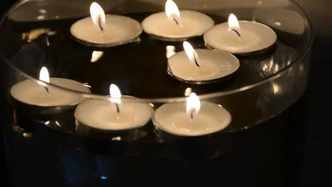 Close up of several floating candles in a glass of water. Beautiful candle light Stock Footage 163079302