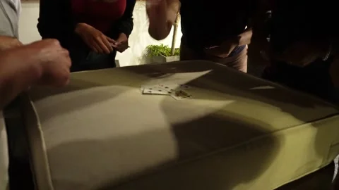 Close-up of several friends playing a card game on a cushion and hitting with Stock Footage 178208438