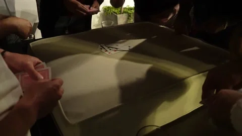 Close-up of several friends playing Nervous, a card game with their hands on the Stock Footage 178207293