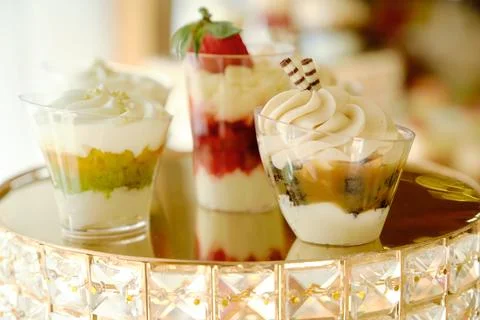 Close-up of several small glasses filled with delicious layered desserts. Stock Photos