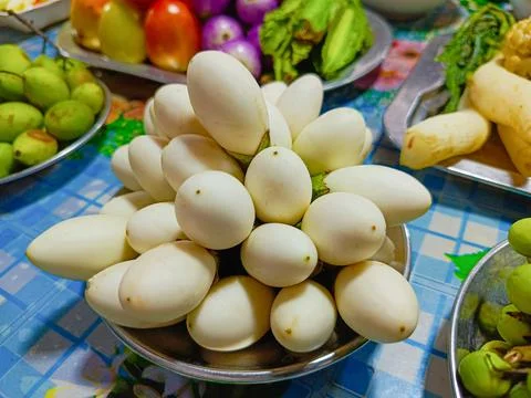Close-up of several small white eggplants are stacked on a full plate. Foto stock