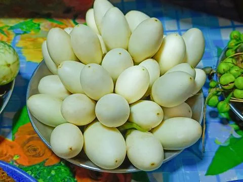Close-up of several small white eggplants are stacked on a full plate. Foto stock
