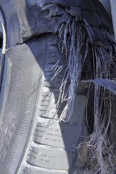 A close-up of a severely damaged and flat car tire. 写真素材