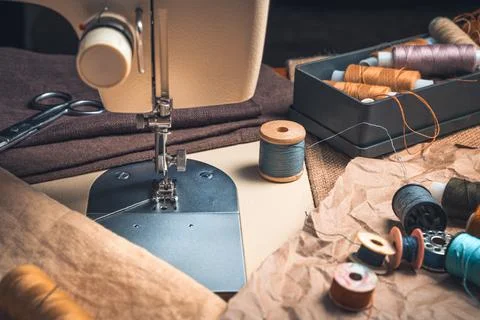 A close-up sewing machine and a set of threads. Side view Stock Photos