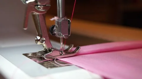 Close up sewing machine foot shocking pink thread on pink cotton Stock Footage 43666348
