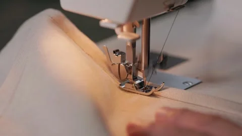 Close up of sewing machine needle and presser foot stitching linen fabric Stock Footage 345456601