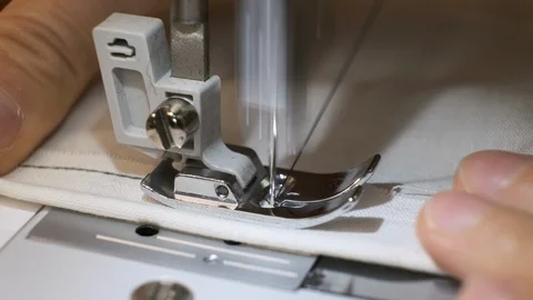 Close-up of sewing machine needle rapidly moves up and down. White fabric Stock Footage 114621961