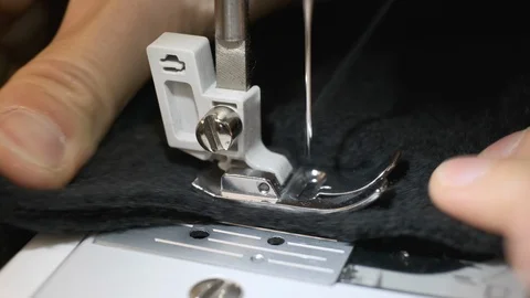 Close-up of sewing machine needle rapidly moves up and down. Black fabric Stock Footage 114622929