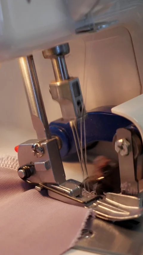 Close up of sewing machine needle rapidly stitching fabric, showcasing the Stock Footage 340841886