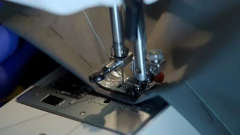 Close-up of sewing machine needle rapidly moves up and down. Stock Photos