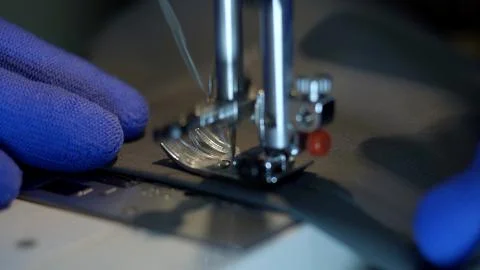 Close-up of sewing machine needle rapidly moves up and down. Stock Photos