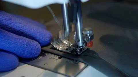Close-up of sewing machine needle rapidly moves up and down. Stock Photos