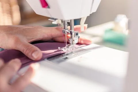 Close-up of sewing machine needle sewing a piece of fabric Stock Photos